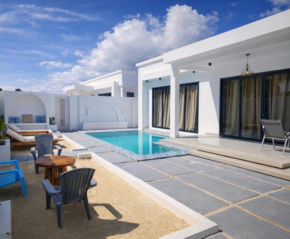 a villa with a swimming pool and a patio at Amour Beach Villas in Paje