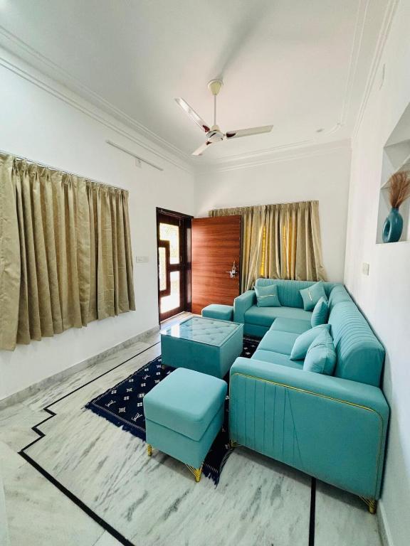 a living room with blue couches and a ceiling at Kozy Cottage udaipur in Udaipur