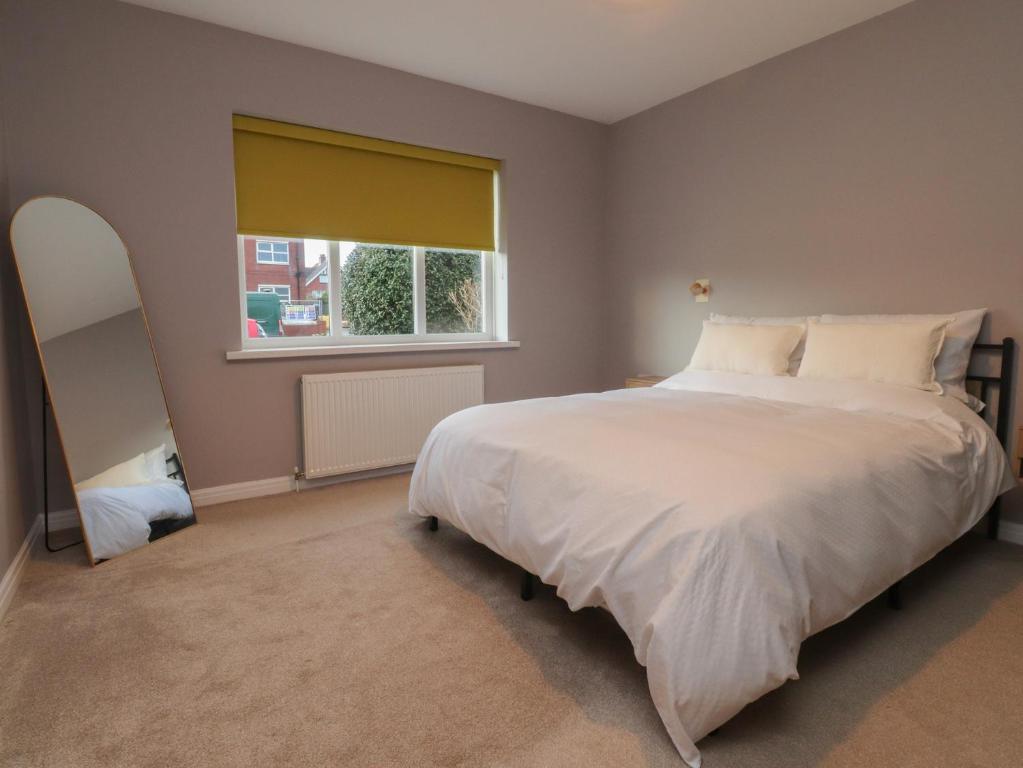 a bedroom with a large bed and a window at Seaside Serenity in Lytham St Annes