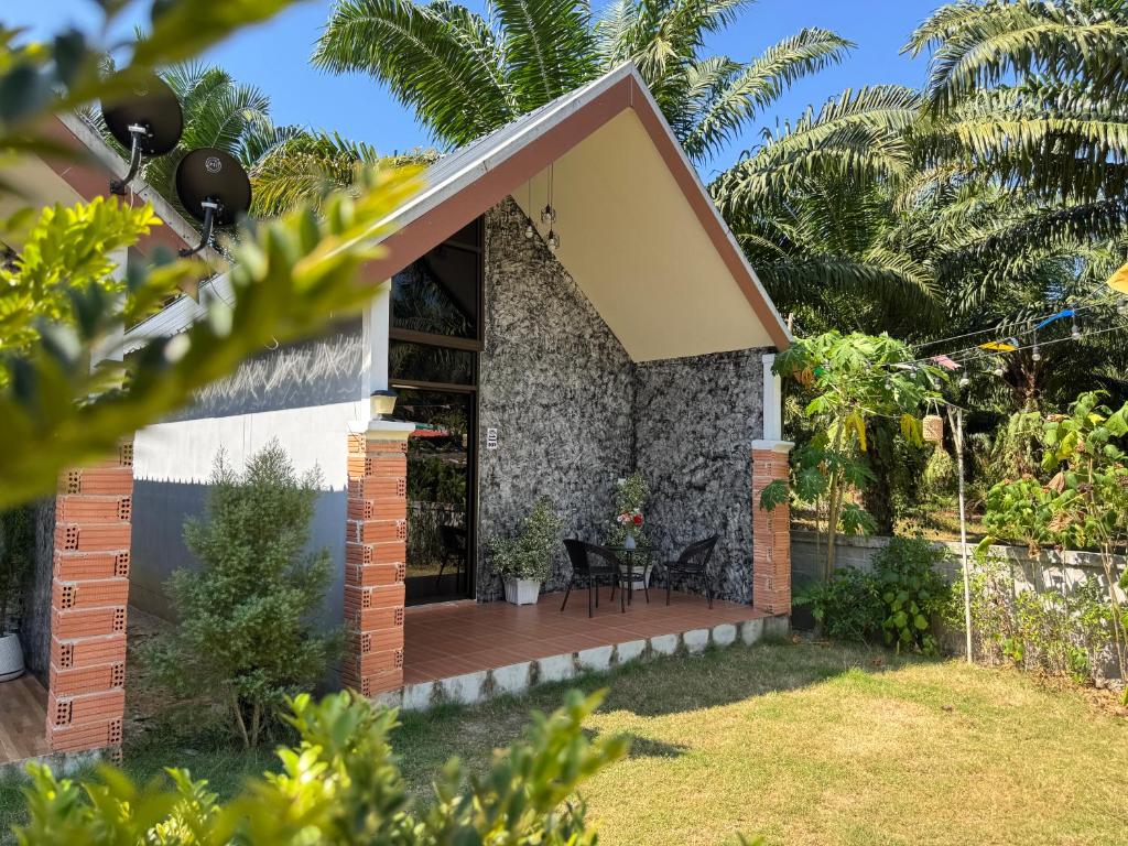 a small house with a deck in a yard at Phak Ploen Home Stay in Ban Rae Mai Phai