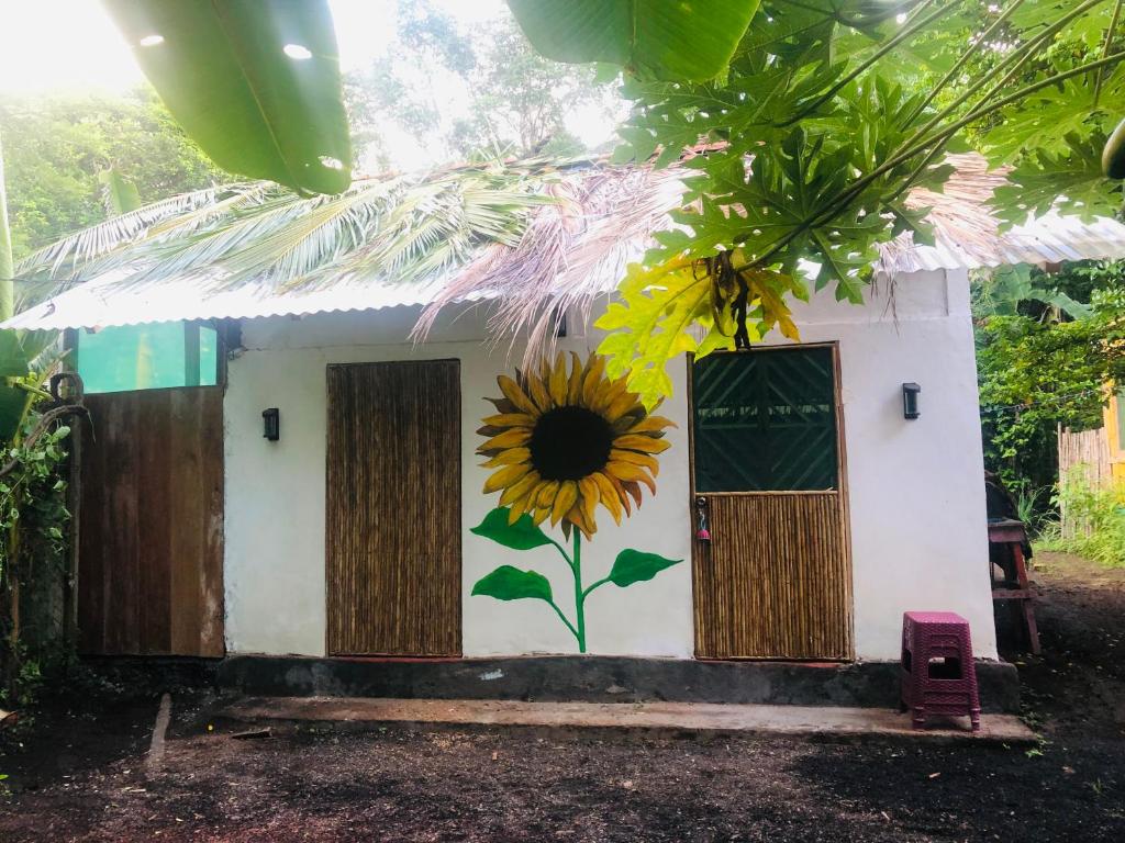 a building with a sunflower painted on it at Sunflower Cottage near Ojo de Agua in Las Pilas