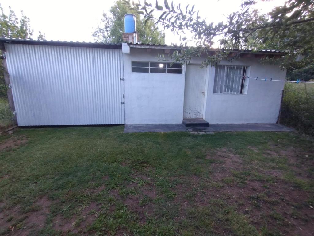 a house with a white garage with a grass yard at Antonio House in Uspallata