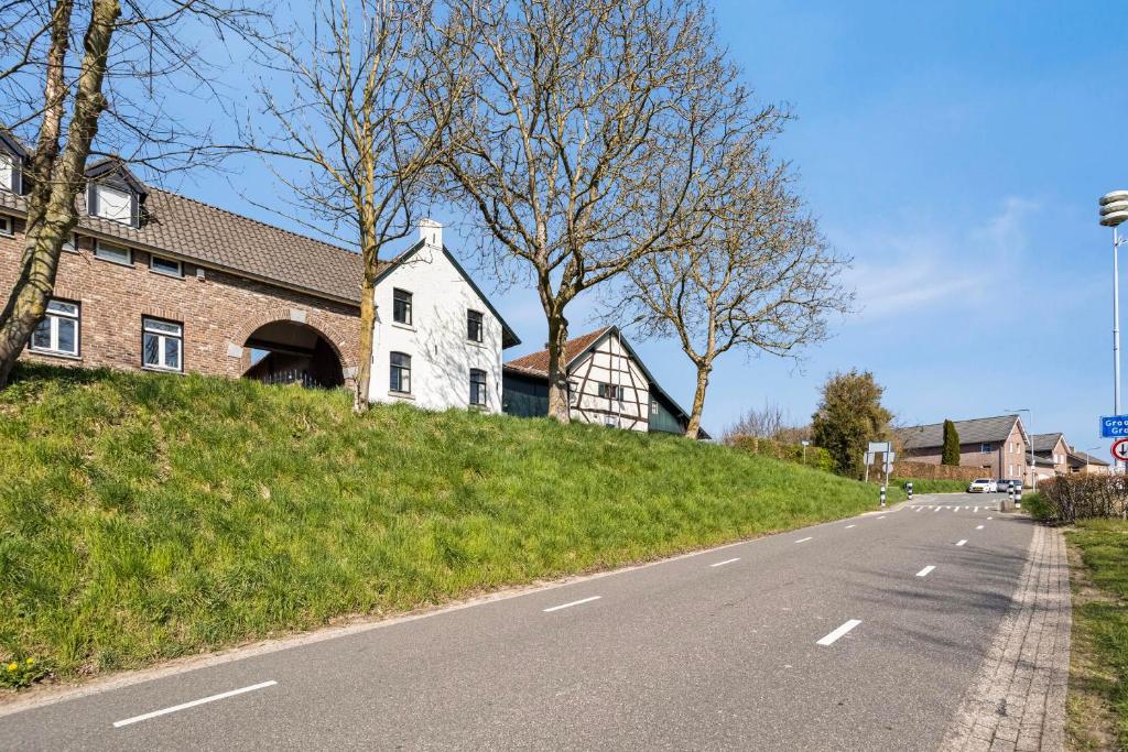 a house on a hill next to a road at boerderij, voorhuis in Schimmert