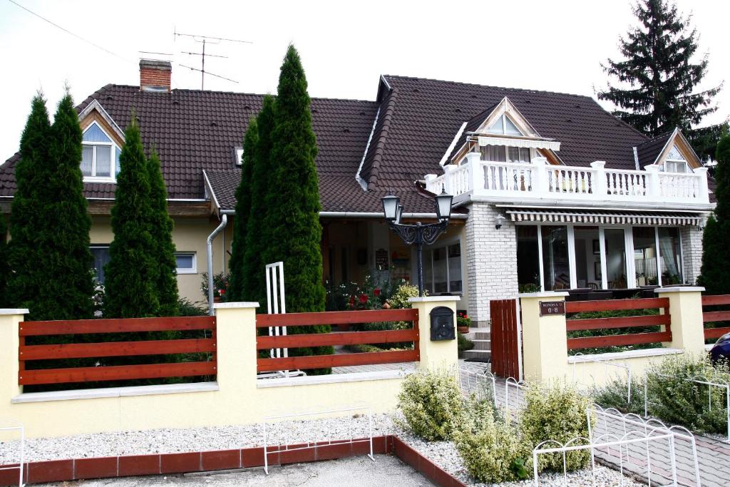 une maison avec une clôture devant elle dans l'établissement Parti Panzió, à Tata