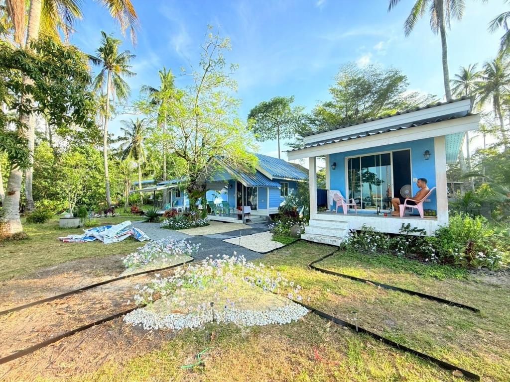 a house with people sitting on the porch of it at Kohmook sunrise beach in Ko Muk