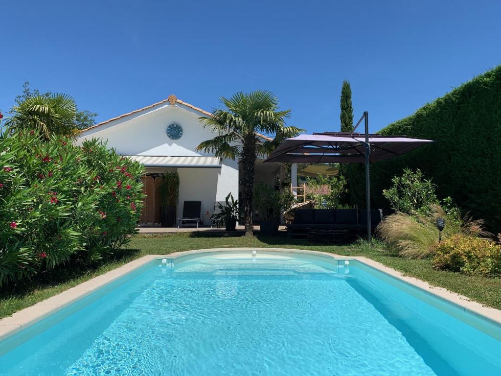 a swimming pool in front of a house at Les Tignoliers in Tignieu-Jameyzieu