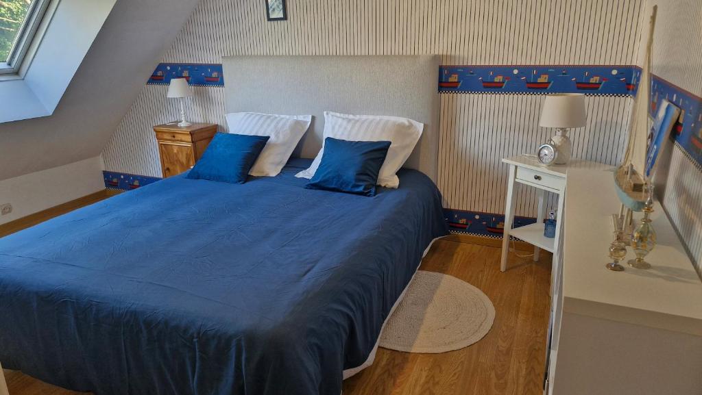 a bedroom with a large bed with blue sheets and pillows at les HAUTS de SAINT SATURNIN in Saint-Saturnin