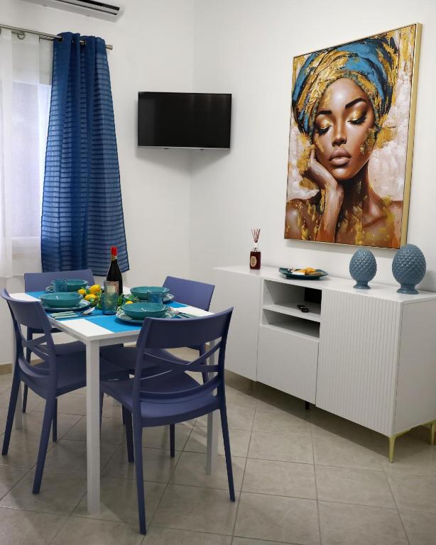 a dining room with a table and a painting of a woman at L'arco Sul Mare in Balestrate
