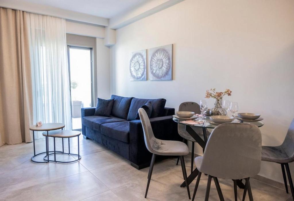 a living room with a blue couch and a table at Peace Home Trikala in Tríkala