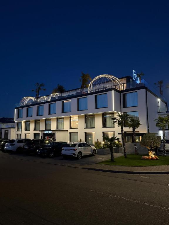 a white building with cars parked in front of it at Hayat Hotels & Apartments in Rust