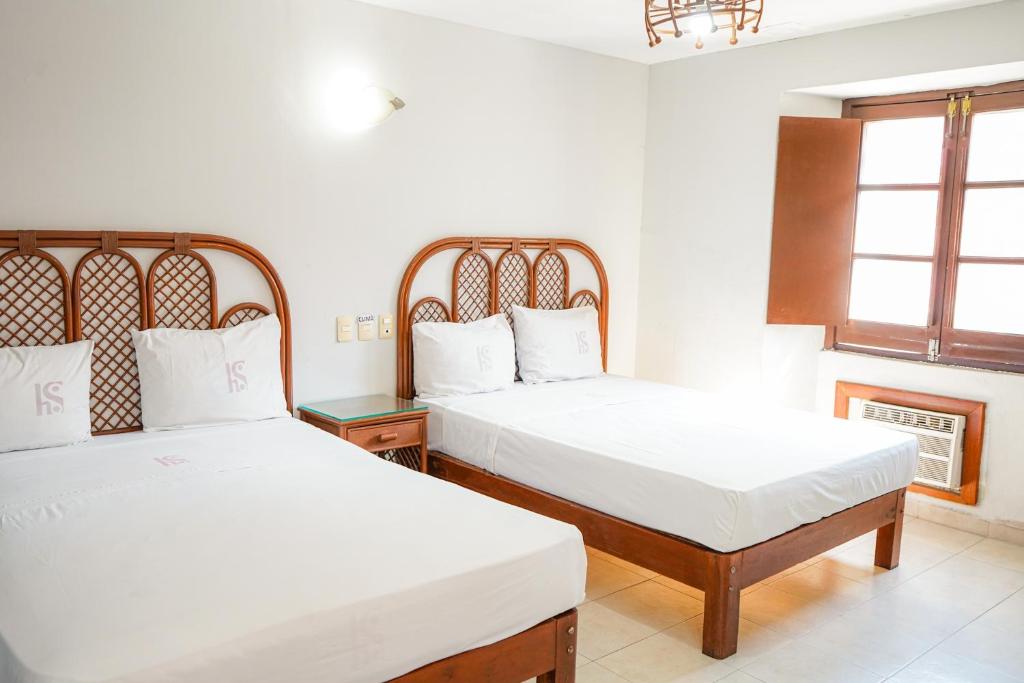 a bedroom with two beds and a window at OYO Hotel Plaza Veracruz Centro Historico in Veracruz