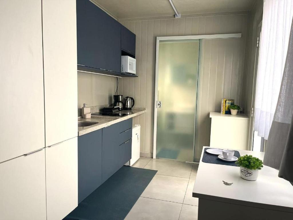 a small kitchen with blue cabinets and a counter at Estudio Vila dos Pescadores in São Francisco do Sul