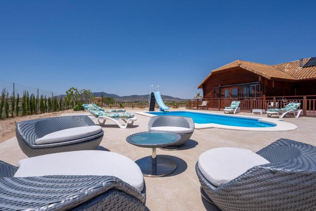 a patio with chairs and a swimming pool at Rustic Villa Retreat in Pinoso