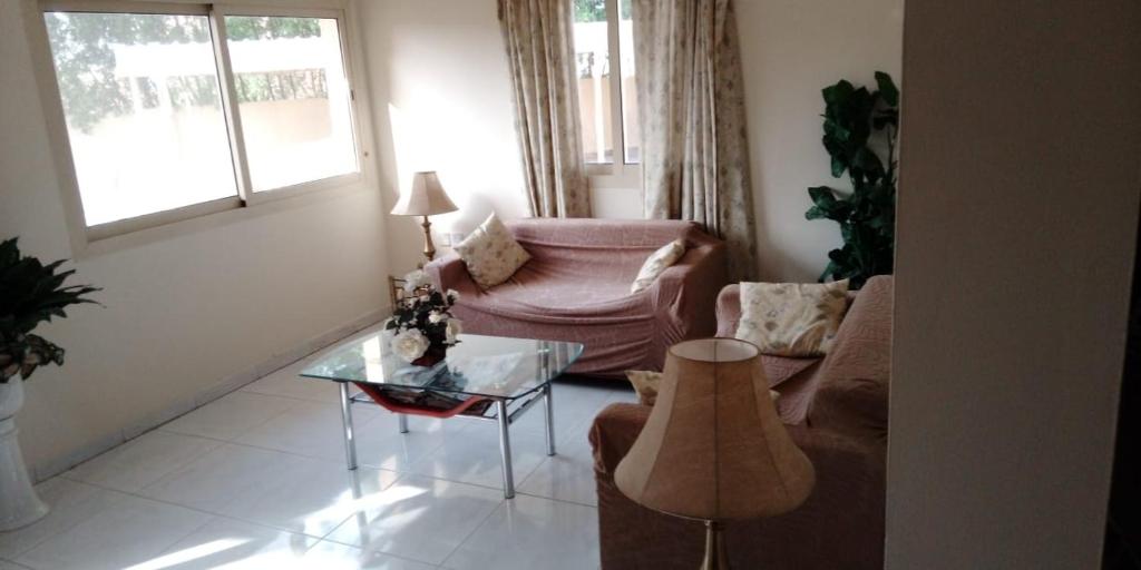 a living room with a couch and a glass table at Beachside Vacation House in Ras al Khaimah