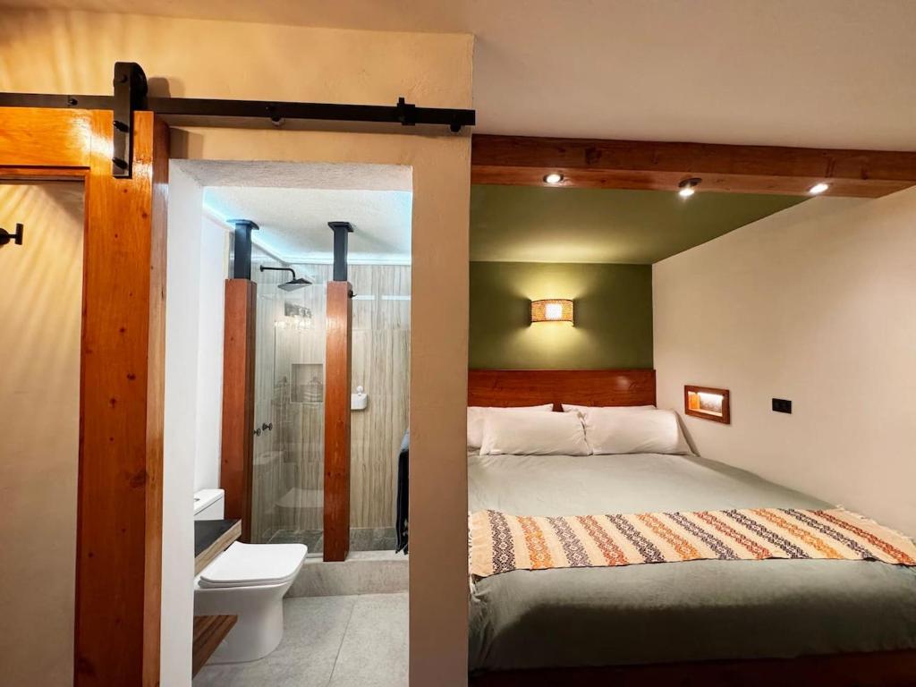 a bedroom with a bed and a bathroom with a shower at Private Room With Jacuzzi, Pool, and Sauna. in San Lucas Tolimán