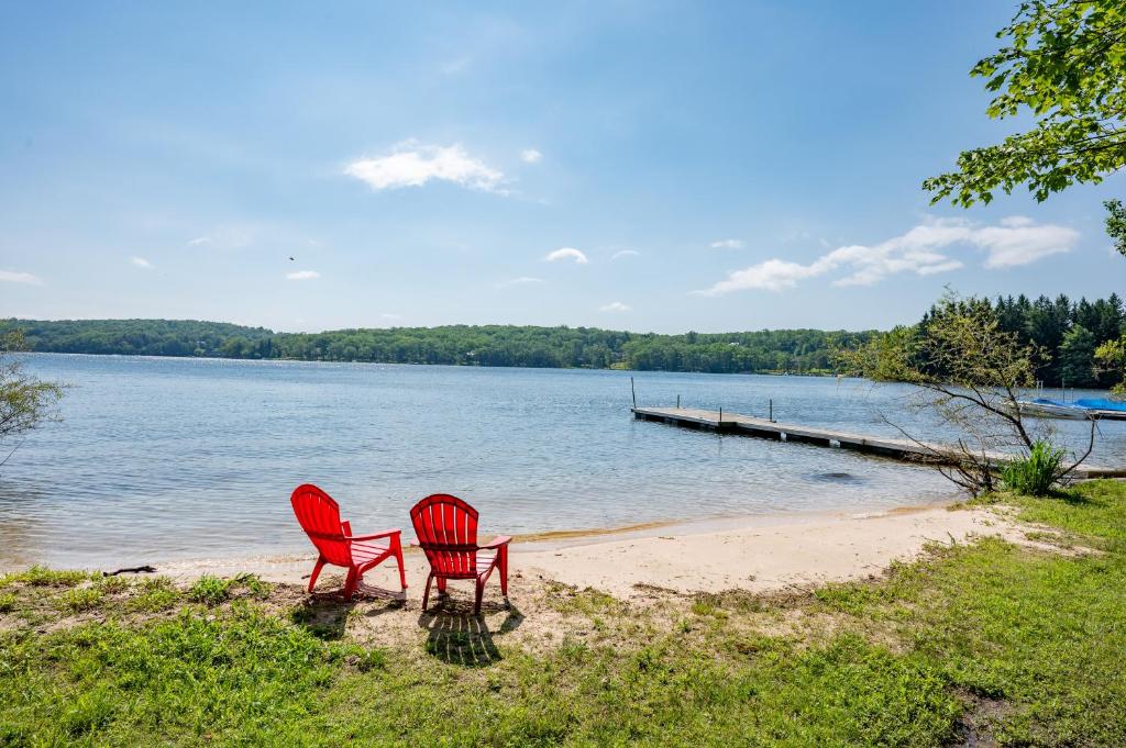 two red chairs sitting on a beach next to a dock at Tolson Cabin by Railey Vacations in Oakland