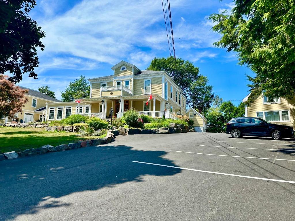 a house with a car parked in a parking lot at Tattingstone Inn in Wolfville