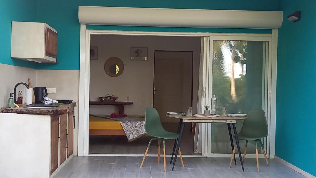 a kitchen with a table and chairs in a room at Studio tout confort - Hameka in Grand-Bourg
