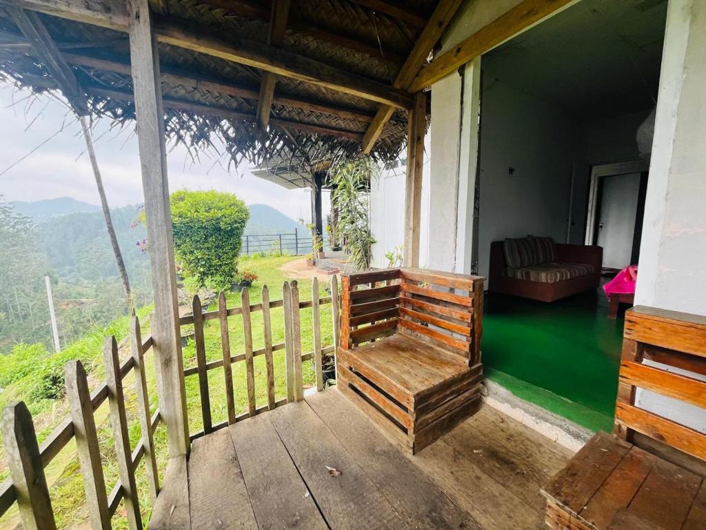 a porch of a house with a couch and a fence at Sisila villa ella in Ella