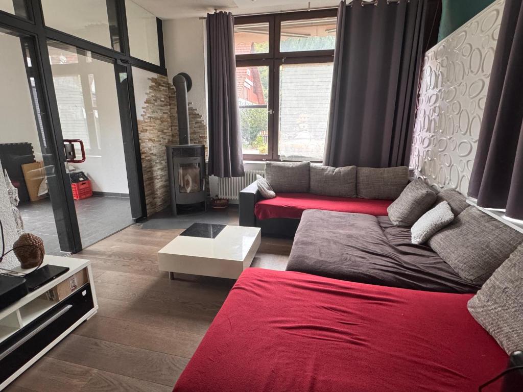 a living room with a couch and a red blanket at Zweizimmer-Häuschen im Schwarzwald in Schopfheim