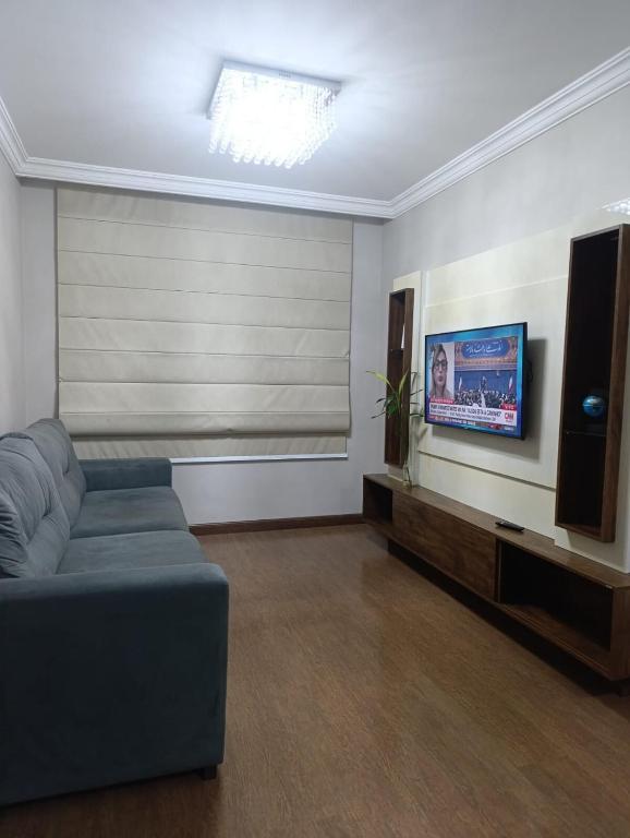 a living room with a couch and a flat screen tv at Jonas e Selma Apartmento 3 quartos in Araucária