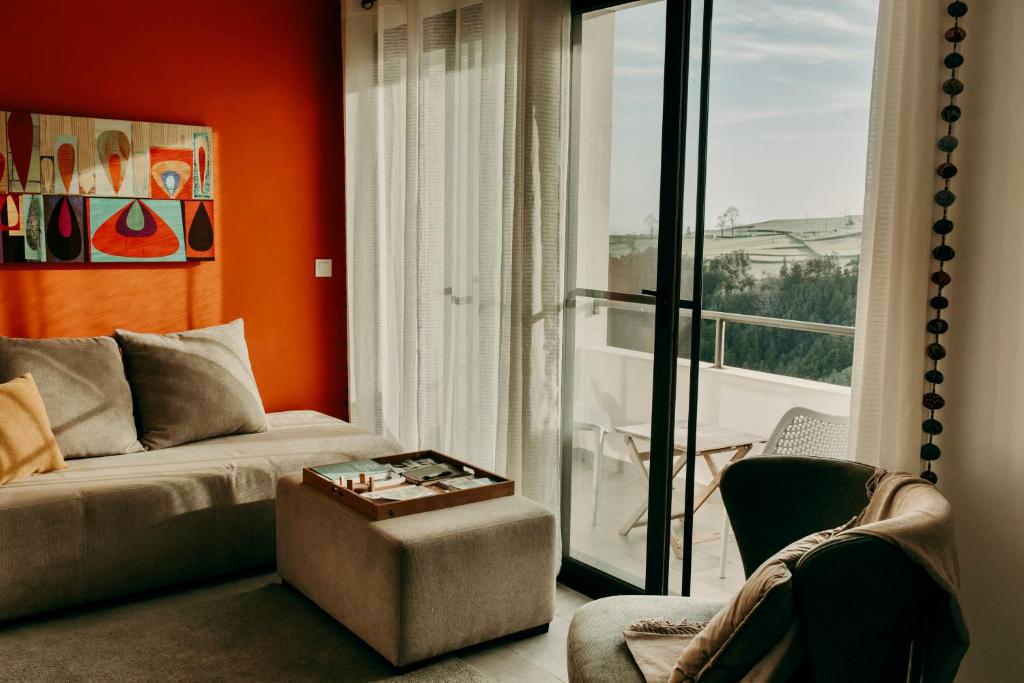 a living room with a couch and a window at Coração da Quinta in Algarvia