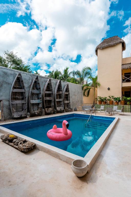 a pool with a pink swan in the middle at Alma de Zorro in Bacalar