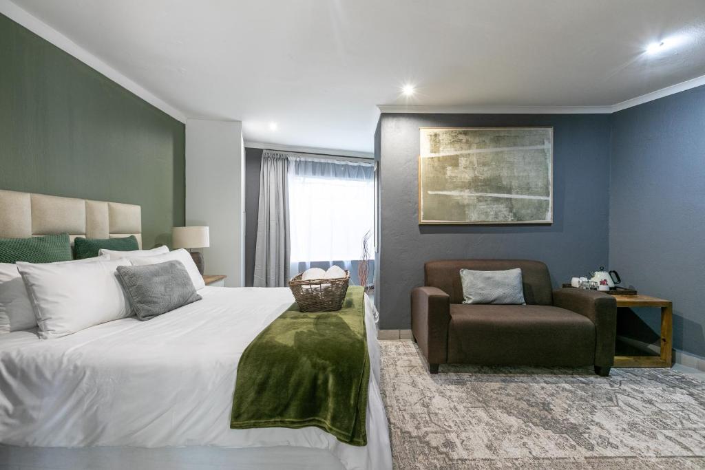 a bedroom with a large bed and a chair at Bella on St James in Johannesburg