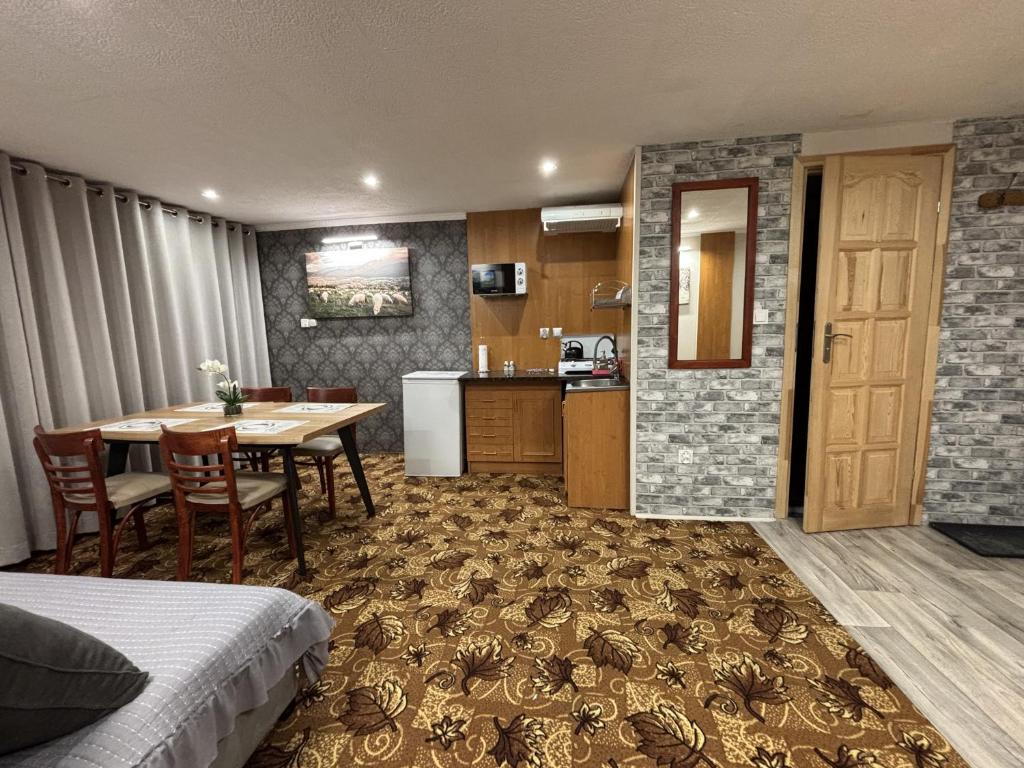 a hotel room with a table and a kitchen at Pokoje u Pawloka - BLISKO TERMY CHOCHOŁOWSKIE in Ciche