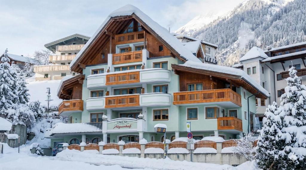 a hotel in the mountains with snow on the ground at Hotel Garni Alpenhof in Ischgl