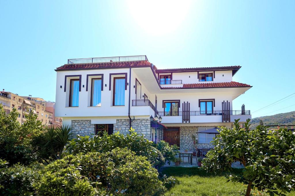 a large white house with blue windows at Villa Starova in Berat