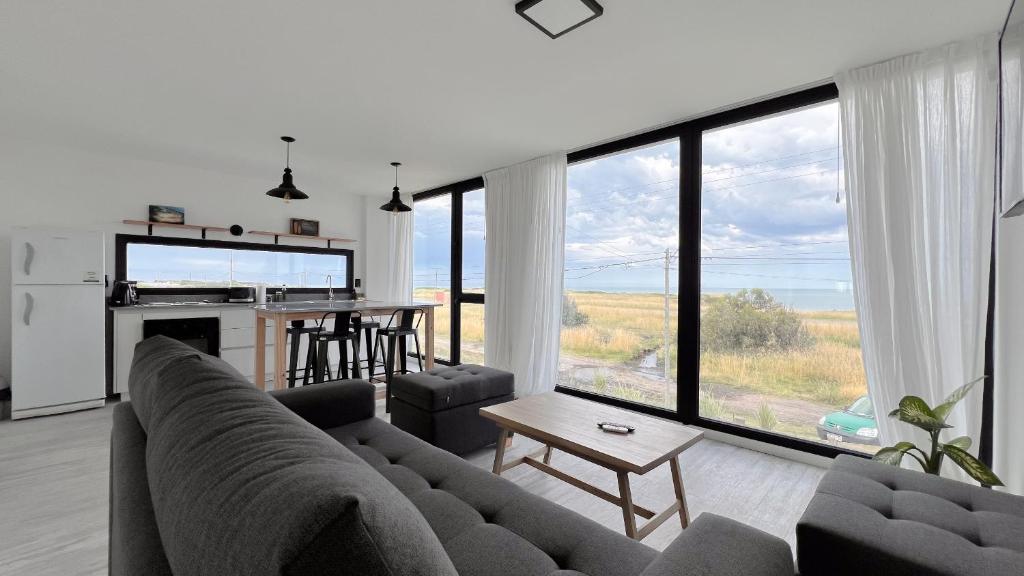 a living room with a couch and a large window at Marea Baja - Casa con vista al mar para 6 PAX con parrilla en Cruz del Sur, Chapadmalal - Hola Sur in Chapadmalal