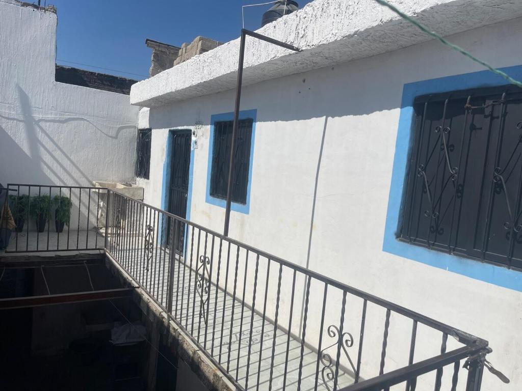 a balcony of a house with a blue door at Departamento Central Camionera in Guadalajara