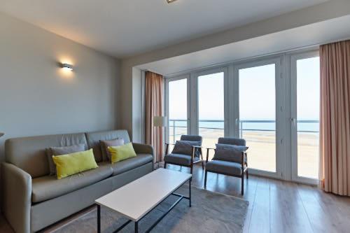 a living room with a couch and a table and chairs at Lecomte - The Shoreline Collection 6 in Ostend