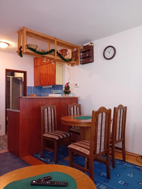a kitchen with a table and chairs and a clock on the wall at Tina in Jahorina