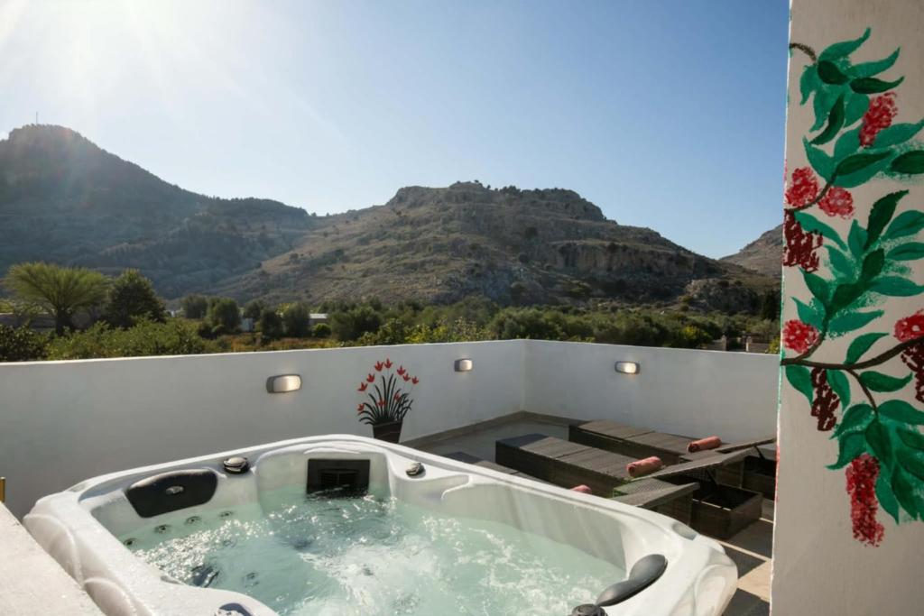 a hot tub on a balcony with mountains in the background at Stergios top view residence with jacuzzi in Kolymbia