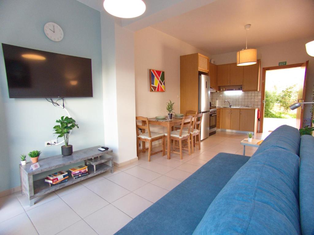 a living room with a blue couch and a kitchen at Peris #2 - Souda in Souda