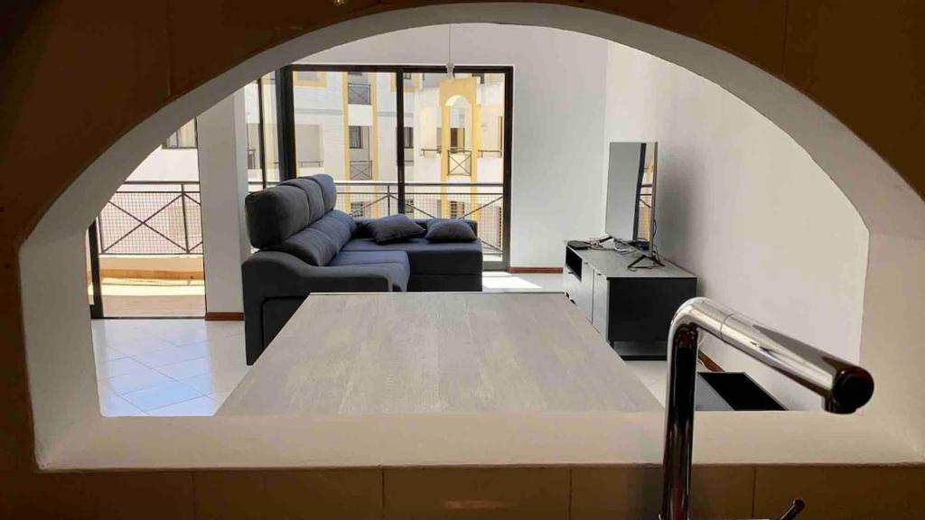 a living room with a couch and a table at Pure Vilamoura 2 bedrooms with pool in Quarteira