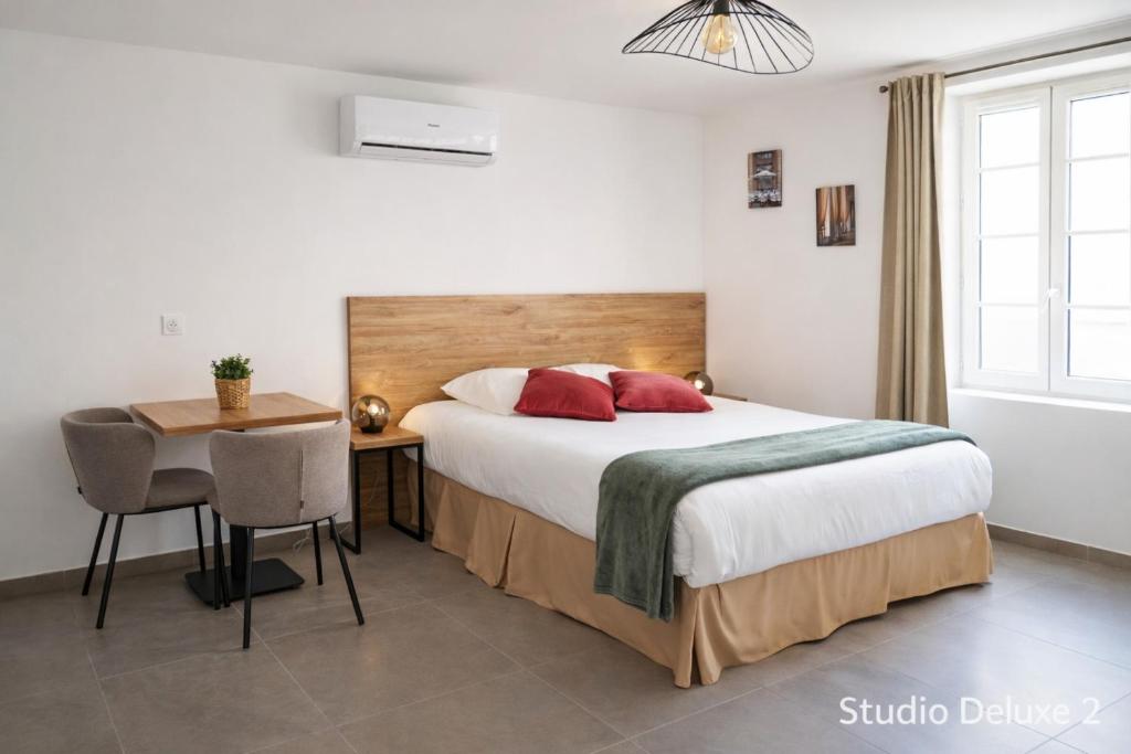a bedroom with a bed and a table and a desk at SOUS LES PLATANES in Velaux