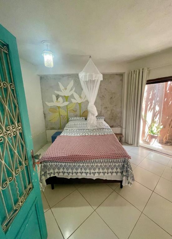 a bedroom with a bed in a room with a window at Cozy Suite Olinda in Olinda