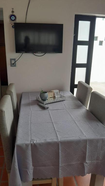 a table with chairs and a television on a wall at La Goldie in Concepción del Uruguay