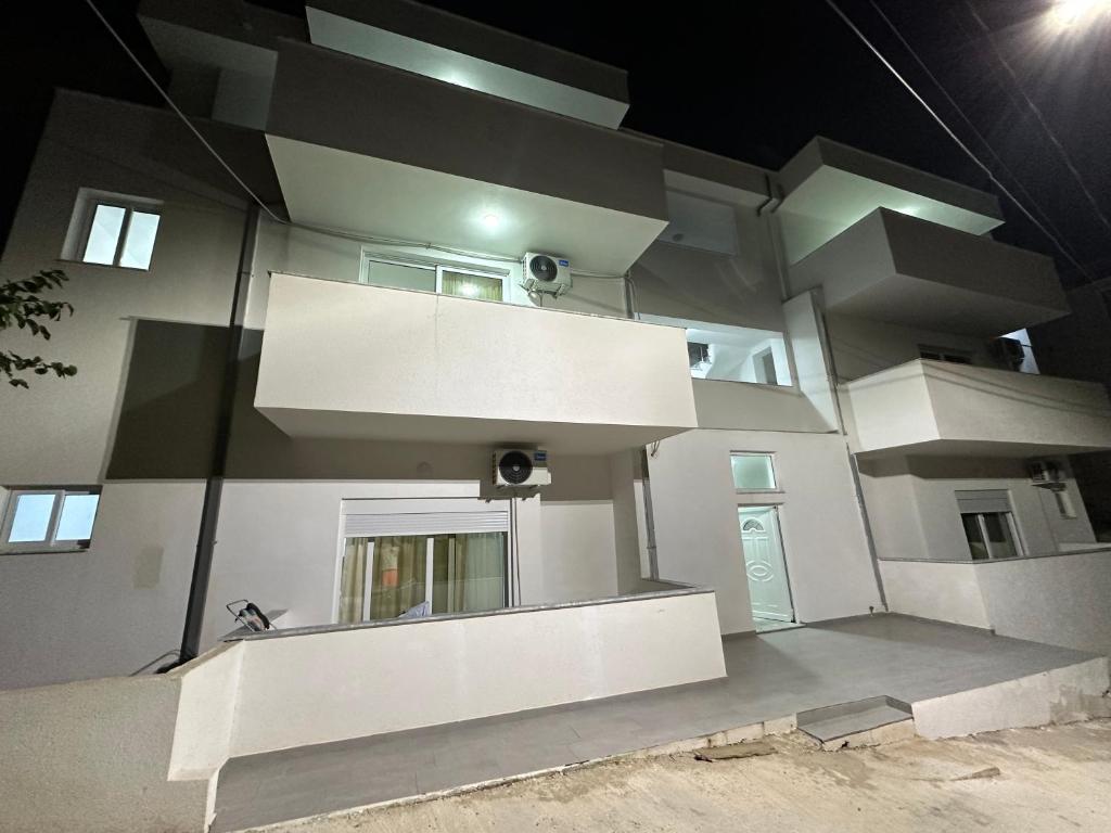 a large white building with a lot of windows at Vila Jovani - Modern Studios with Free Parking, Quiet Area,8 min Walk to Beach in Sarandë