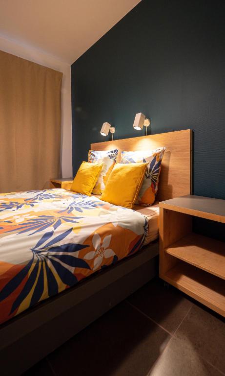 a bedroom with a large bed with yellow pillows at Au Petit Pierrot in Spa