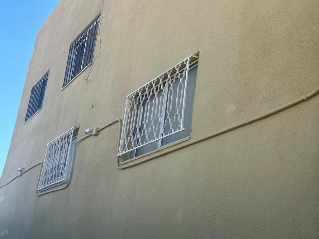 a building with three windows with bars on it at Jalal House in Amman