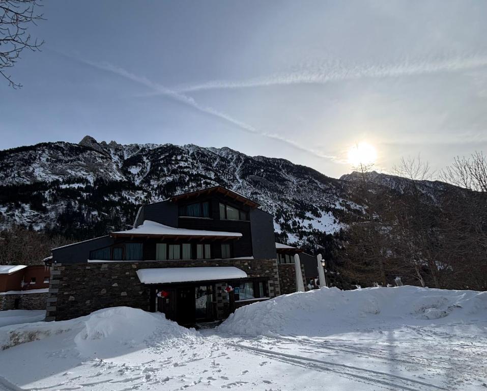 a building in the snow in front of a mountain at HOTEL TURPÍ in Benasque