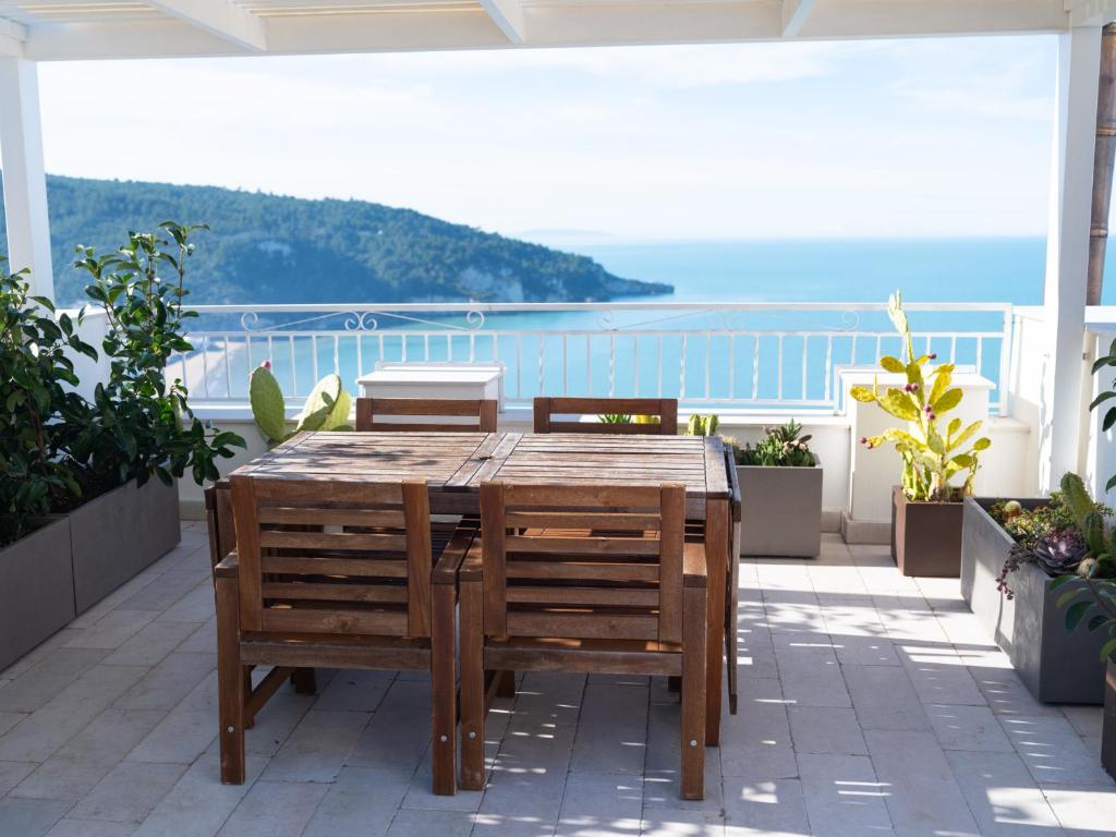 a wooden table and chairs on a balcony with the ocean at Vico Lungo 9, Peschici in Peschici