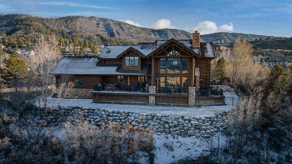 a large log house with a stone wall at 526 Alan Rd - Durango CO. in Durango