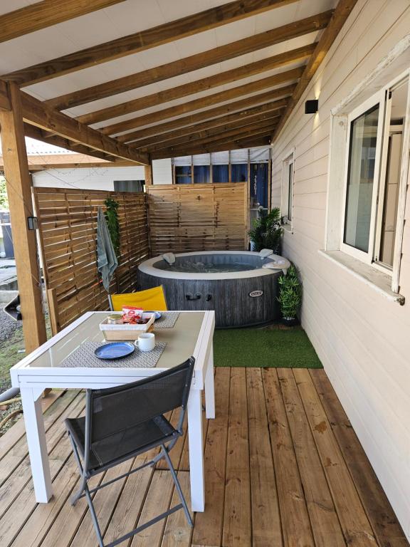 a patio with a table and a hot tub at Contain'House Paradise in Les Abymes