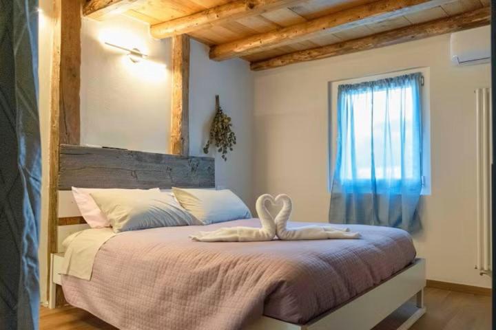 a bedroom with a large bed with a large window at GIAMI affittacamere & SPA in Santa Giustina