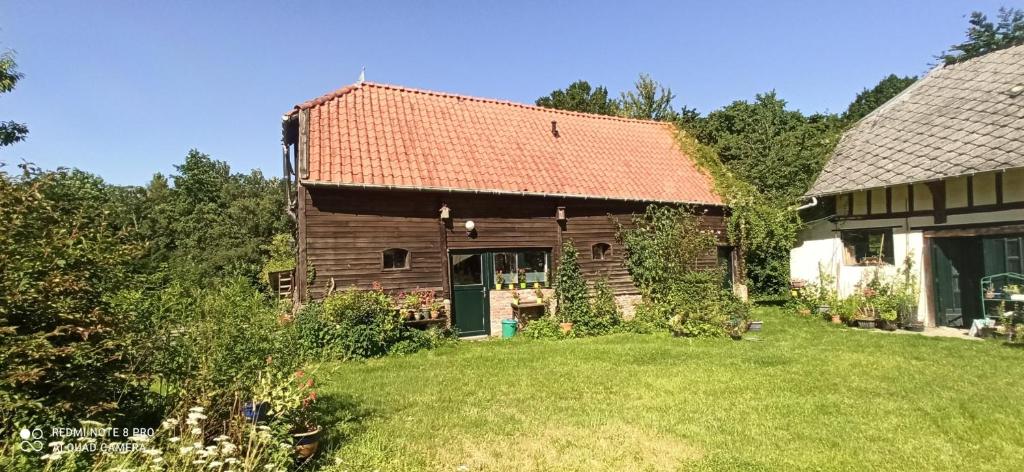 an old house with a red roof on a yard at Gîte de la Gagée in Besmont